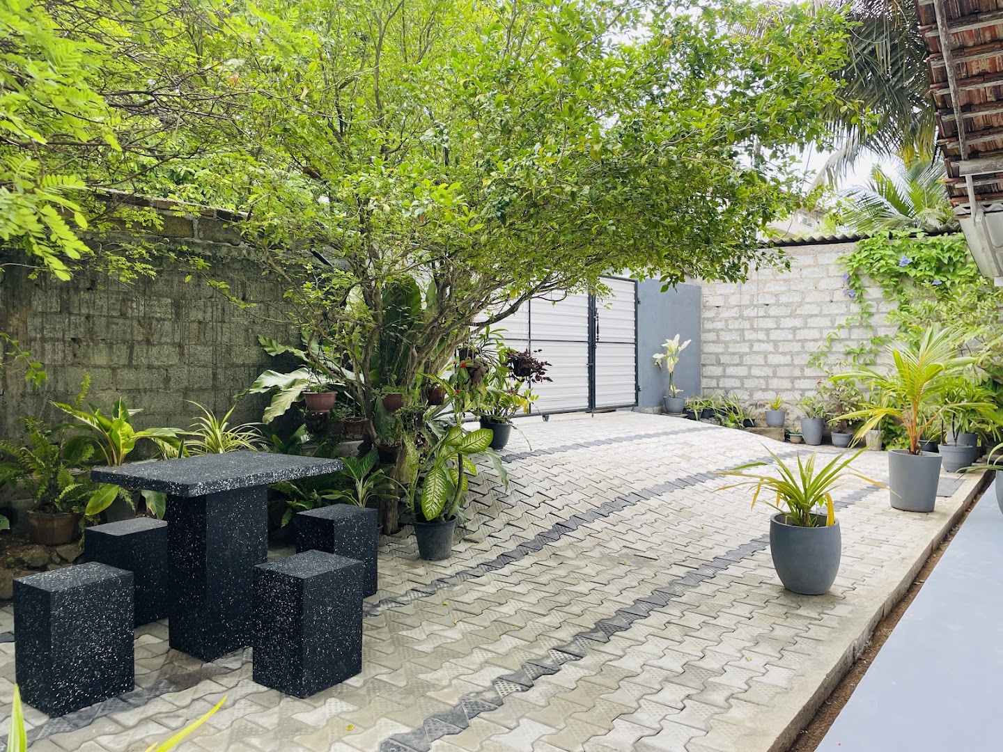 Leafy garden courtyard with stone seating and patterned paving